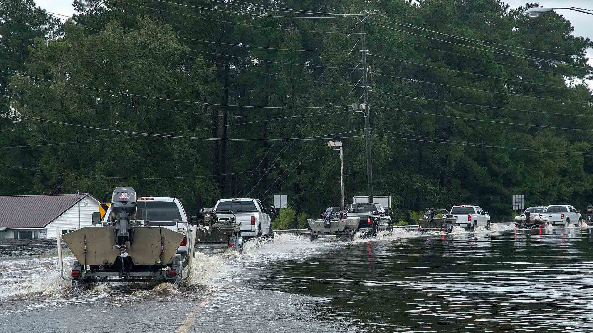 cajun navy boats driving down a flooded road 1